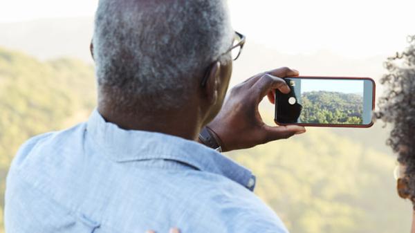 Couple taking picture of mountain landscape