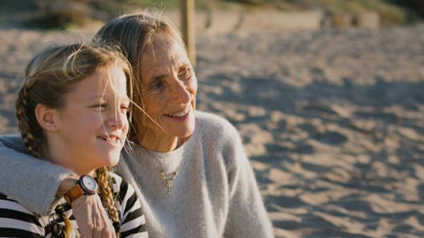 Grand mother and child sitting on the beach