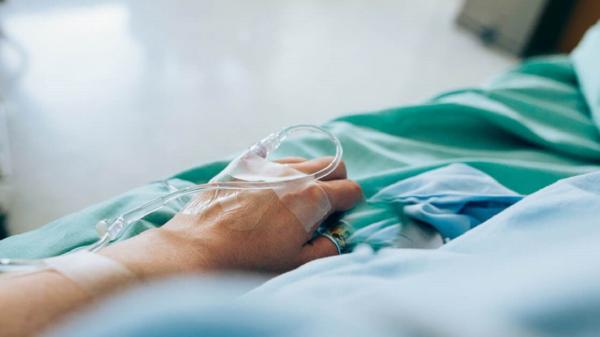 Patient lying on a medical bed with iv catheter 